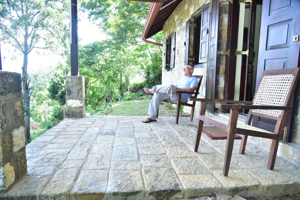 Man Relaxing on Kithul Cottage Verandah